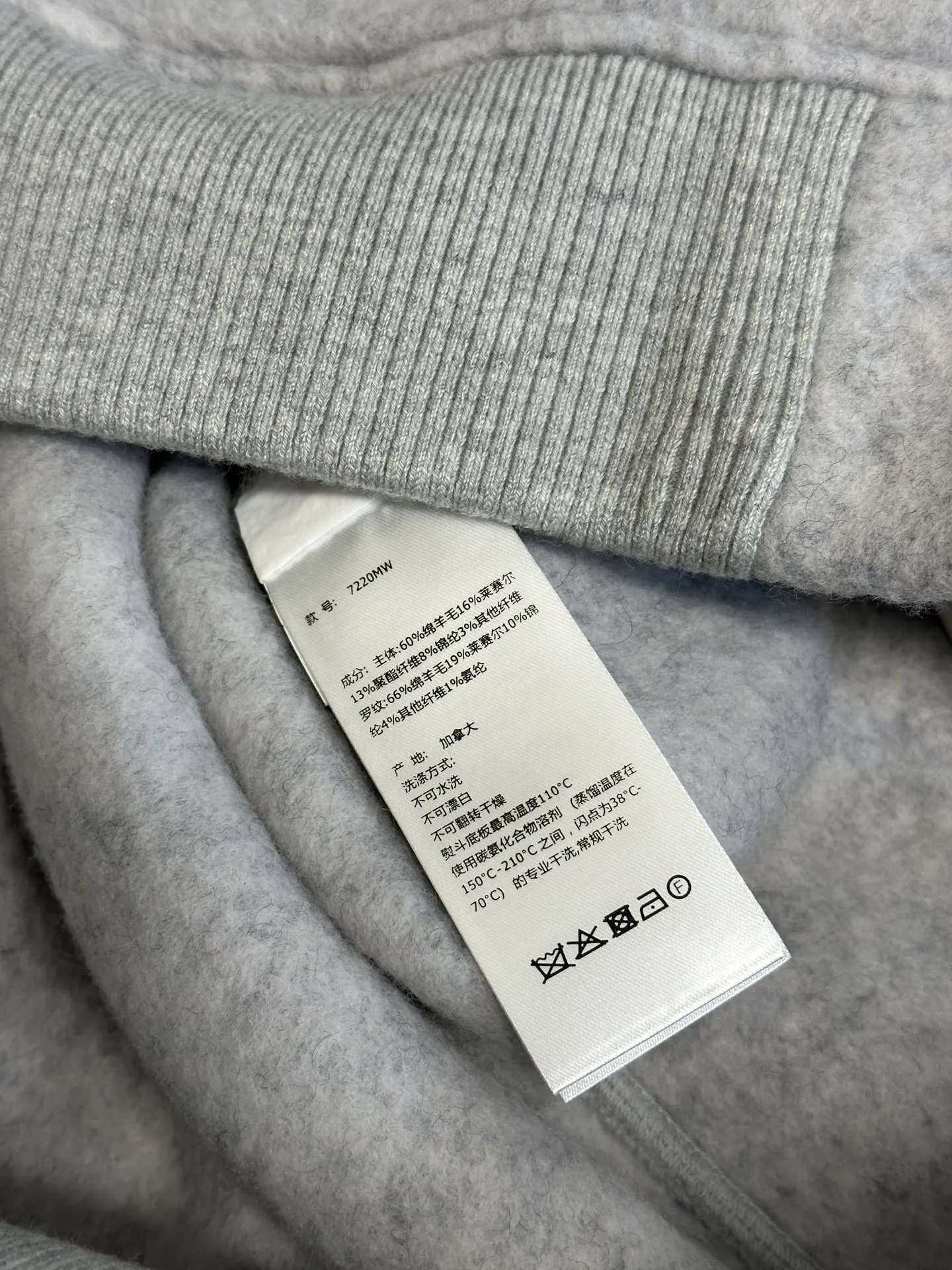 P770 Canada Goose Fleece Badge Button Jacket The main fabric of this jacket is light gray wool blend fabric to improve the fabric's wear resistance, wrinkle resistance and warmth. Wool provides good warmth and a natural feel, while blended fibers enhance the fabric's practicality and durability.  The cutting process needs to ensure that the texture and color of the fabric are evenly distributed, especially with this light gray tone, to avoid chromatic aberrations. The stretchability of wool-blend fabrics needs to be taken into consideration when cutting pieces to ensure dimensional stability of the finished garment.  Use a sewing needle and thread suitable for wool-blend fabrics to avoid damage to the fabric during sewing. The sewing stitches are even and firm to prevent thread stripping.  The temperature needs to be controlled during ironing to avoid high temperature damage to the fabric while keeping the fabric smooth and crisp. The front and back body parts, sleeves and other main parts are stitched with flat seams to ensure a smooth silhouette. Align the fabric texture at the splices to keep the look neat.  The white circular armband on the left arm is an important part of the brand identity and is finely sewn to ensure it is strong and flat.  size：s m l xl